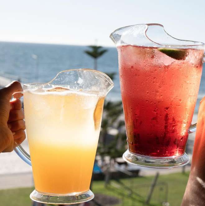 Group enjoying Seamore's value-driven 2-hour bottomless cocktail jugs and pizza package in Henley Beach.